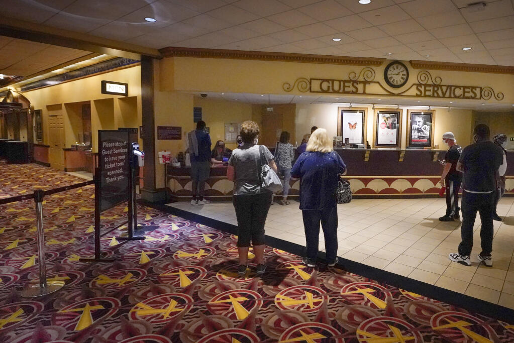 Patrons gather to get tickets for some of the first showings at the AMC theatre when it re-opened for the first time since shutting down at the start of the COVID-19 pandemic, Thursday, Aug. 20, 2020, in West Homestead, Pa. (AP Photo/Keith Srakocic)