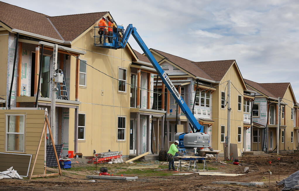 Construction workers place siding on a unit at Windsor Veterans Village in Windsor on Tuesday, Feb. 9, 2021. The project includes 60 affordable housing units for low-income veterans and their families. (Christopher Chung/ The Press Democrat)