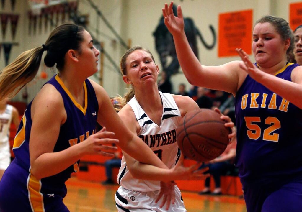 Santa Rosa's Kelly Lueken (3), center, grabs a rebound but gets battered between Ukiah's Kennedy Lynch (50), left, and Adriana Franco (52) during the first half of a girls varsity basketball game between Ukiah and Santa Rosa high schools in Santa Rosa, California on Tuesday, February 16, 2016. (Alvin Jornada / The Press Democrat)
