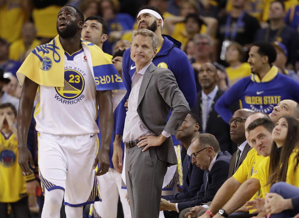 Golden State Warriors head coach Steve Kerr, center, watches during the first half of Game 3 of the NBA Western Conference final against the Houston Rockets in Oakland, Sunday, May 20, 2018. (AP Photo/Marcio Jose Sanchez)