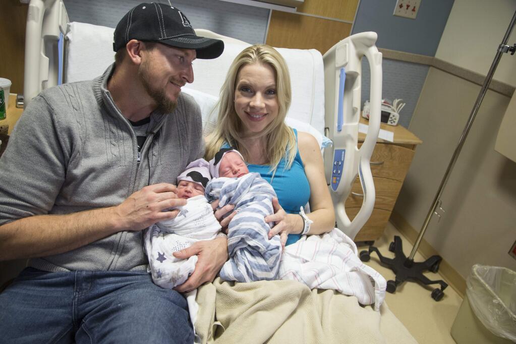 In a Jan. 1, 2017 photo, Brandon Shay, and his wife Holly of Glendale, Ariz., hold their new born twins at at Banner Hospital in Glendale. The couple welcomed their first son, Sawyer, right, into the world at 11:51 p.m. Saturday. Their second son, Everett, arrived one minute after midnight on Sunday. (Nick Oza/The Arizona Republic via AP)