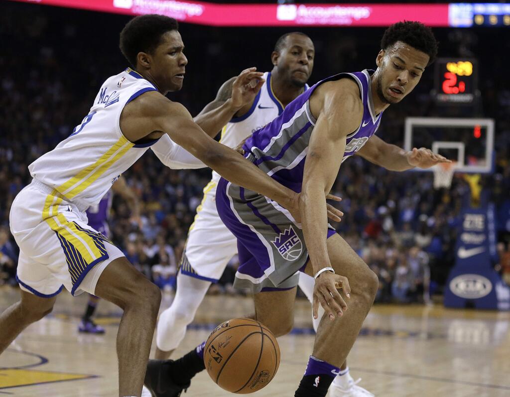 The Golden State Warriors' Patrick McCaw, left, and Andre Iguodala defend against the Sacramento Kings' Skal Labissiere, right, during the first half Monday, Nov. 27, 2017, in Oakland. (AP Photo/Ben Margot)