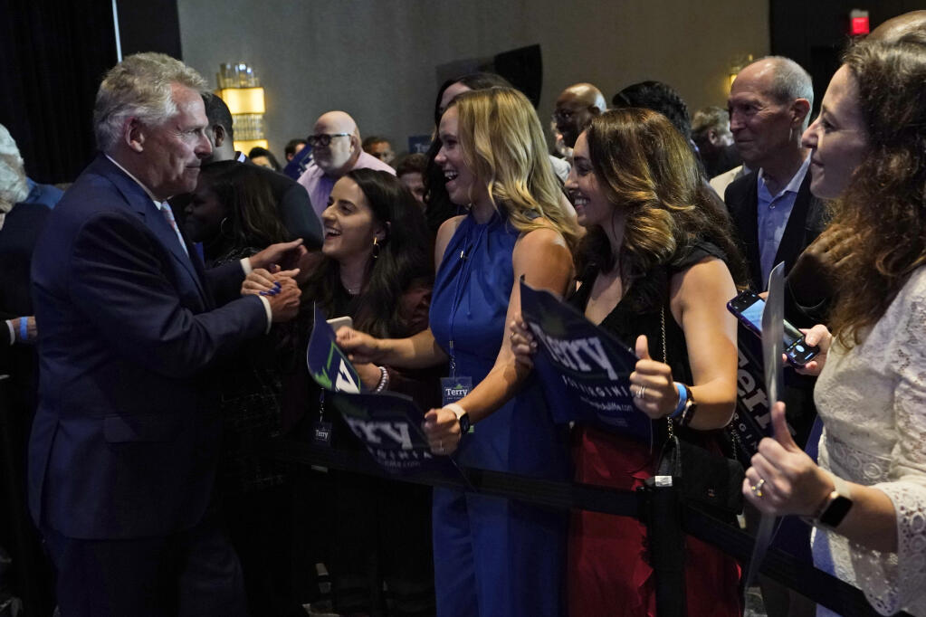 Winner of the Virginia Democratic gubernatorial primary, former Virginia Gov. Terry McAuliffe, left, greets supporters during an election party in McLean, Va., Tuesday, June 8, 2021. McAuliffe faced four other Democrats in Tuesday's primary. (AP Photo/Steve Helber)