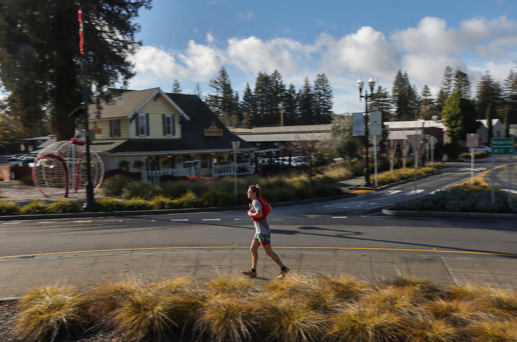 Runner Tate Dobson runs counterclockwise around the roundabout in Healdsburg on Sunday, Dec. 11, 2022. Dobson ran the roundabout in clockwise circles for six hours on Nov. 30, and decided to run the opposite direction for another six hours. (Christopher Chung/The Press Democrat)