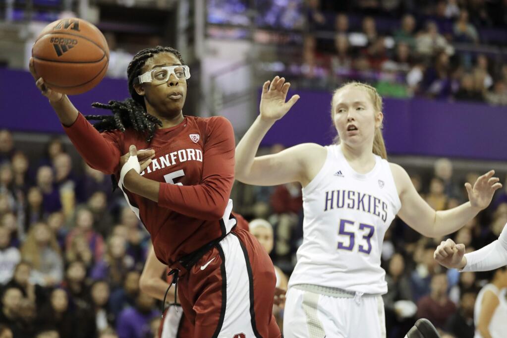 Stanford forward Francesca Belibi, left, passes the ball in front of Washington center Darcy Rees (53) during the first half of an NCAA college basketball game Friday, Jan. 31, 2020, in Seattle. (AP Photo/Ted S. Warren)