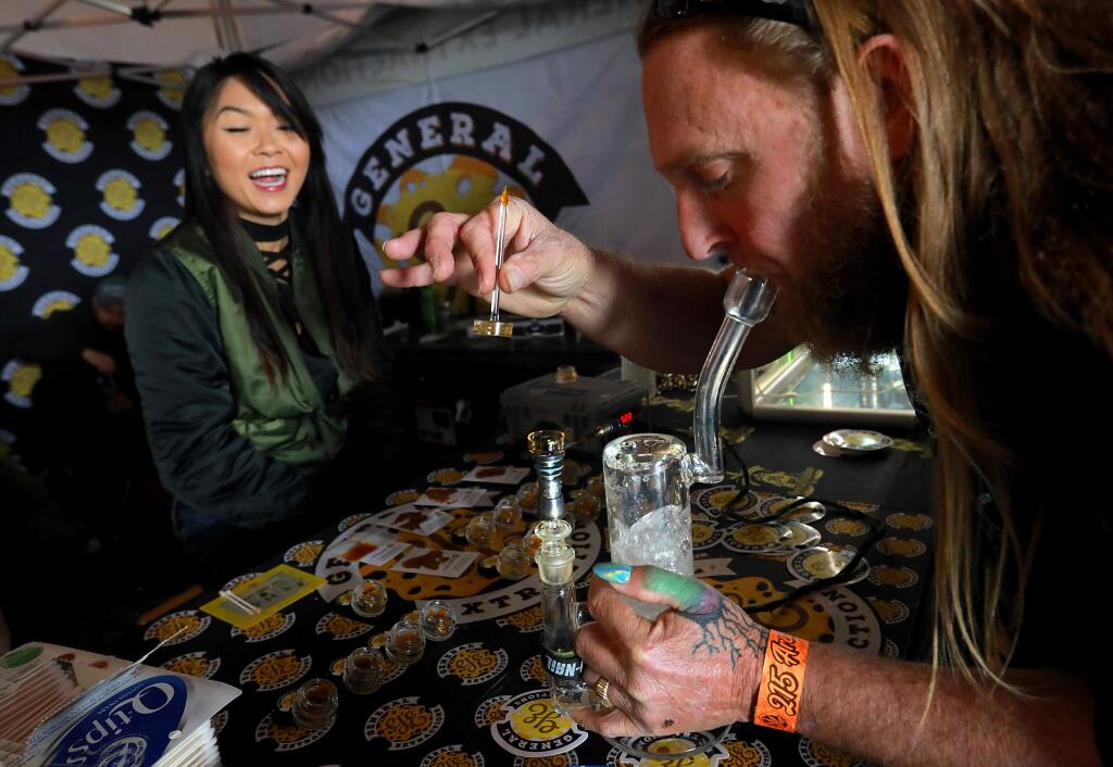 Fergz Farmz tires a dab from Christine Nguyen with General Extractions of Sacramento at the 17th annual Emerald Cup festival at the Sonoma County Fairgrounds on Saturday, December 9, 2017. (photo by John Burgess/The Press Democrat)