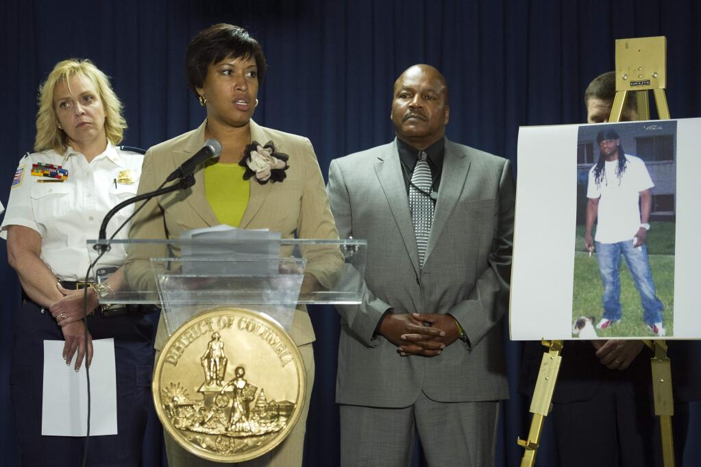 Washington Mayor Muriel Bowser, center, flanked by Police Chief Cathy Lanier, left, and Special Agent in Charge Charlie Smith, Bureau of Alcohol, Tobacco, Firearms and Explosives, speaks during a news conference in Washington, Thursday, May 21, 2015, on the investigation into the mysterious slayings of a wealthy Washington family and their housekeeper. (AP Photo/Cliff Owen)