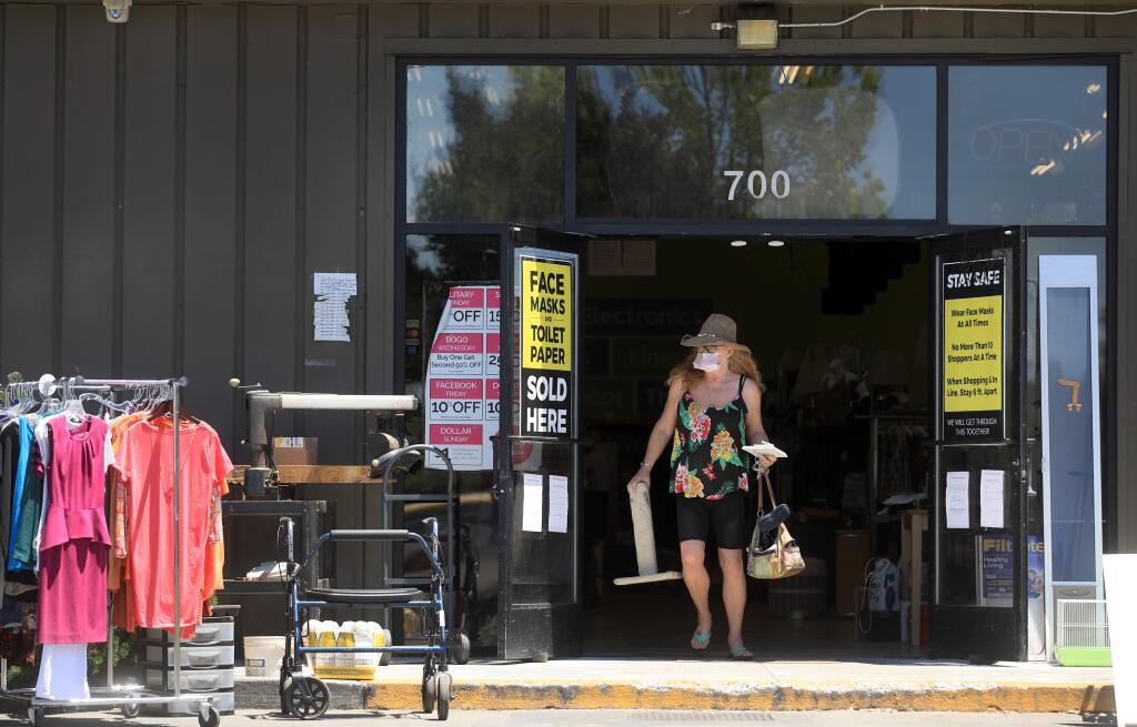 A customer leaves with her purchases through the front entrance of Crossing the Jordan, Wednesday, May 27, 2020 on Piner Road in Santa Rosa. (Kent Porter / The Press Democrat) 2020