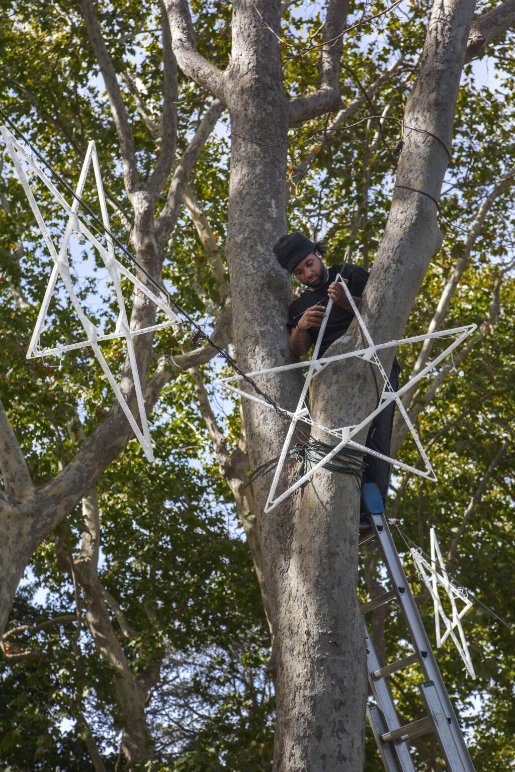Niqeel Wyndham, of Christmas Lights Pros, hung stars on the Plaza on Thursday, Oct. 24, in preparation for the Plaza Christmas lighting celebration. (Photo by Robbi Pengelly/Index-Tribune)