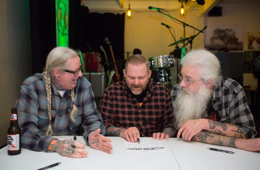 Judges Donavan Kinyon, left, of Golden Owl Tattoo, Scott Sprouse, of Wild Bills Tattoo, center, and Adam Lunoe, of Imperial Tattoo in Portland, OR. consult during the third annual Ugly Tattoo Contest held at B&V Whiskey Bar & Grille in Sonoma, Calif. Sunday, March 19, 2017. The event was a fundraiser benefiting Planned Parenthood (Jeremy Portje / For The Press Democrat)