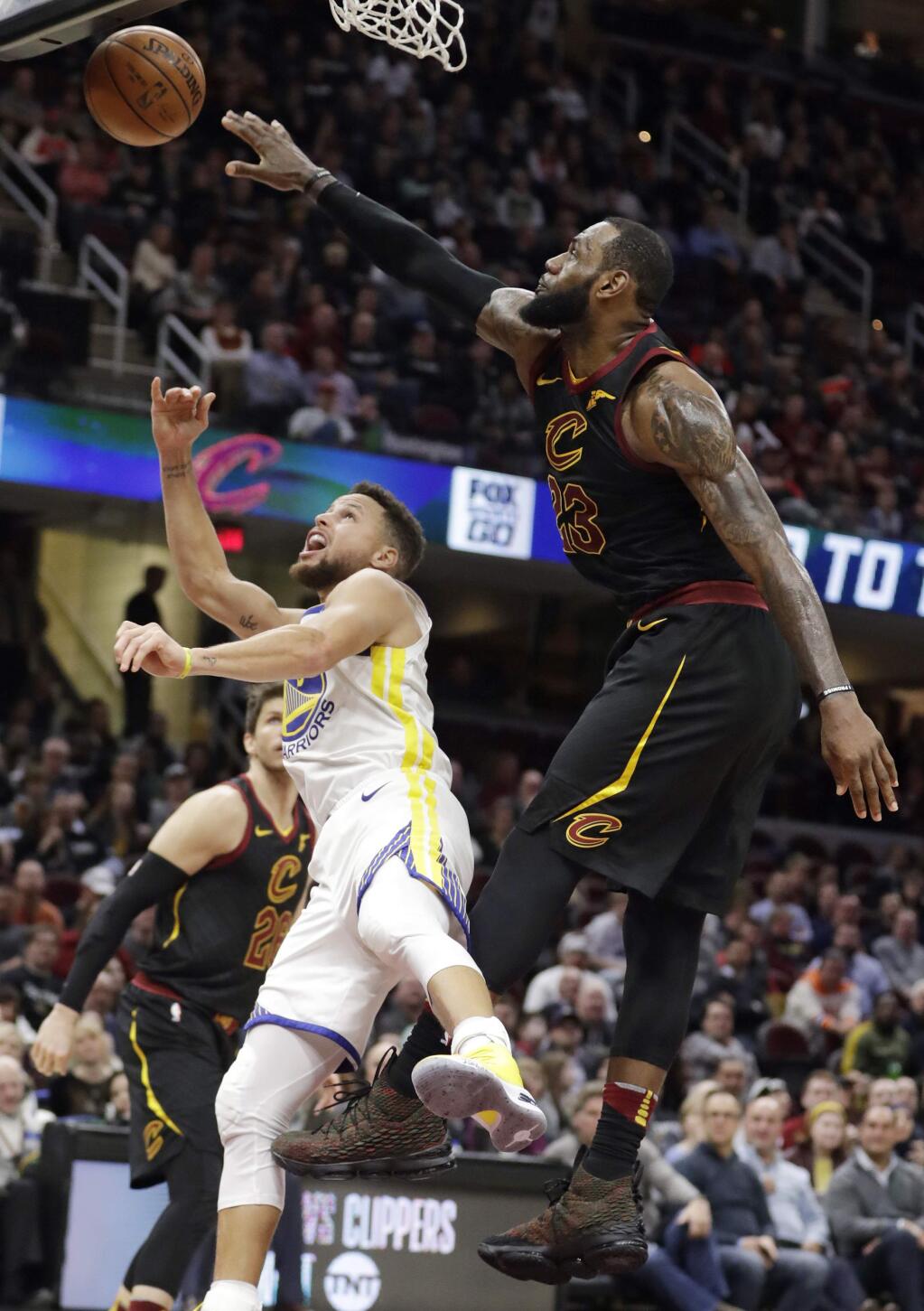The Cleveland Cavaliers' LeBron James blocks a shot by the Golden State Warriors' Stephen Curry, left, in the second half Monday, Jan. 15, 2018, in Cleveland. (AP Photo/Tony Dejak)