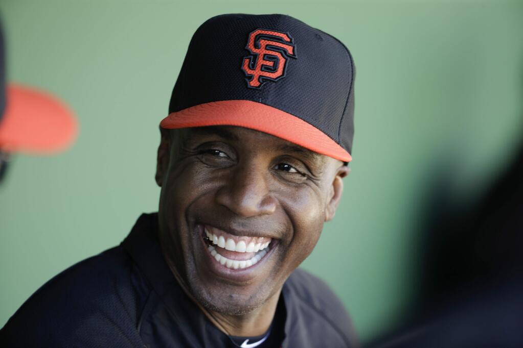 In this March 10, 2014, file photo, former San Francisco Giants Barry Bonds chats in the dugout during a spring training baseball game in Scottsdale, Ariz. (AP Photo/Chris Carlson, File)