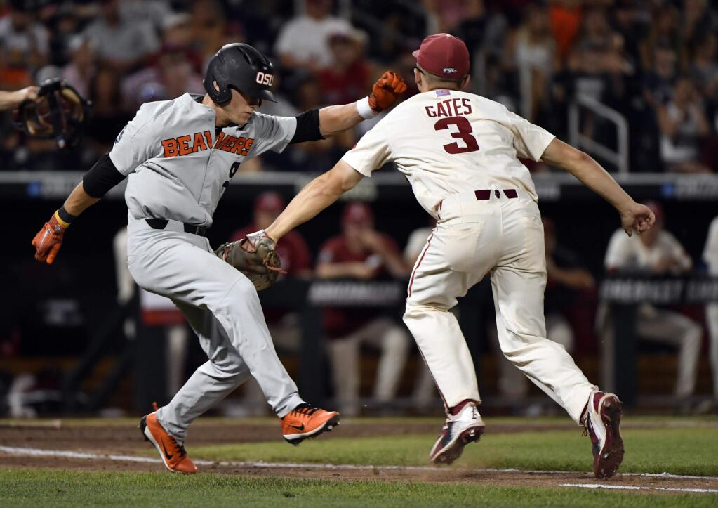 Oregon State's Andy Armstrong (9) is tagged out by Arkansas' Jared Gates (3) during the ninth inning in Game 2 of the NCAA College World Series baseball finals in Omaha, Neb., Wednesday, June 27, 2018. (AP Photo/Ted Kirk)