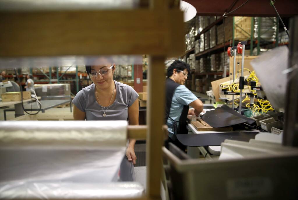 Cecilia Argos, left, and Christina Chavez assemble keyboard trays at Workrite Ergonomics on Tuesday, May 3, 2016 in Petaluma, California . (BETH SCHLANKER/ The Press Democrat)