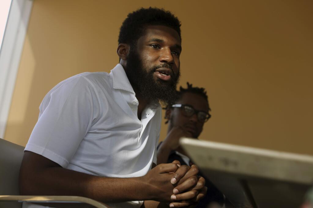 In this April 18, 2018 photo, Rashon Nelson, left, speaks as Donte Robinson, right, looks on during an interview with The Associated Press in Philadelphia. Their arrests at a local Starbucks quickly became a viral video and galvanized people around the country who saw the incident as modern-day racism. In the week since, Nelson and Robinson have met with Starbucks CEO Kevin Johnson and are pushing for lasting changes to ensure that what happened to them doesn't happen to future patrons. (AP Photo/Jacqueline Larma)