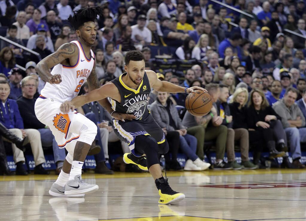 Golden State Warriors guard Stephen Curry, right, dribbles past Phoenix Suns' Elfrid Payton during the first half of an NBA basketball game Monday, Feb. 12, 2018, in Oakland, Calif. (AP Photo/Marcio Jose Sanchez)