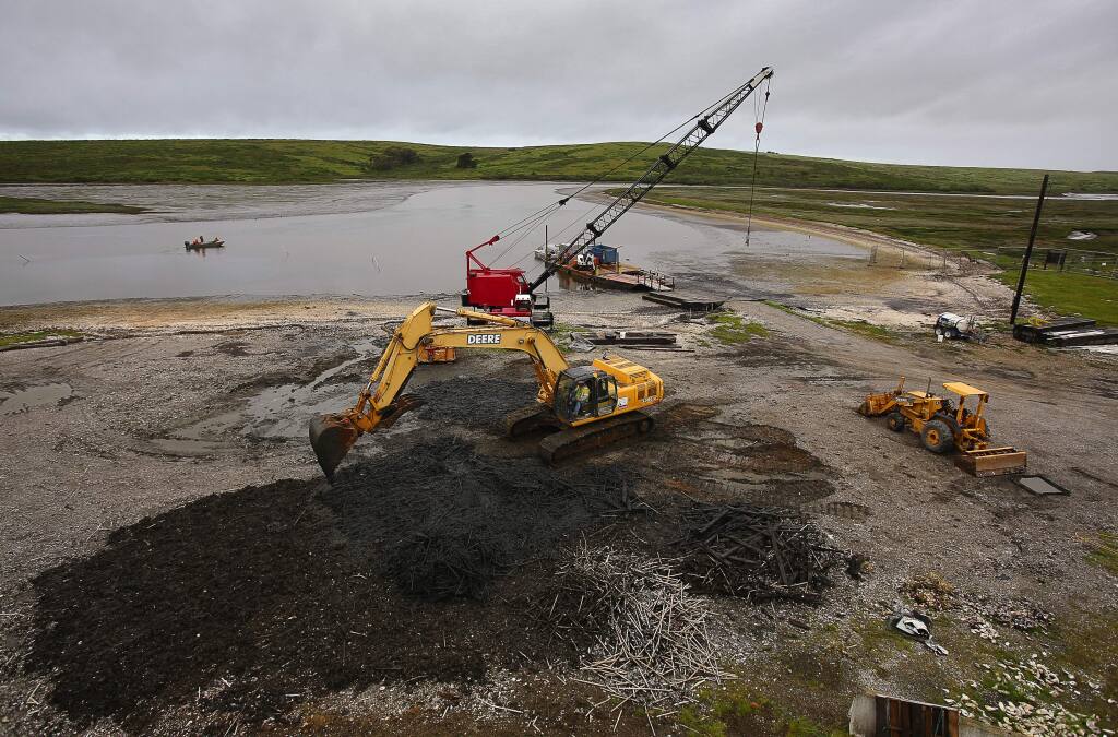 An excavator moves oyster farming materials removed from Drakes Estero, in the Point Reyes National Seashore, related to the Drakes Bay Oyster Company's operation, on Wednesday, April 12, 2017. (Christopher Chung/ The Press Democrat)