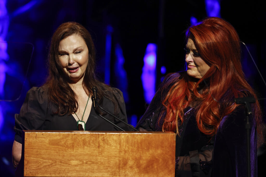Ashley Judd, left, cries as she speaks while sister Wynonna Judd listens during the Country Music Hall of Fame Medallion Ceremony Sunday, May 1, 2022, in Nashville, Tenn. (Photo by Wade Payne/Invision/AP)