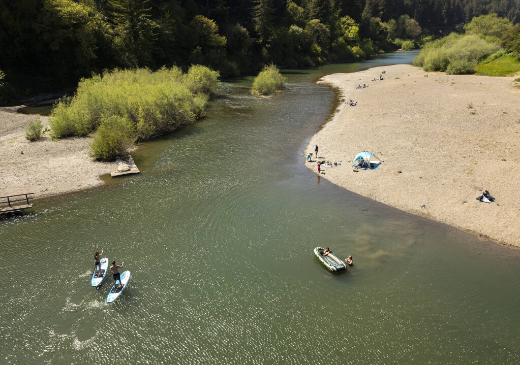 Sage Wild and Amy Melman head down the Russian River on their stand-up paddle boards on Wednesday, April 14, 2021. A very dry winter and historically low water levels in Lakes Sonoma and Mendocino will lead to a difficult summer recreation season on the Russian River.  (John Burgess/The Press Democrat)