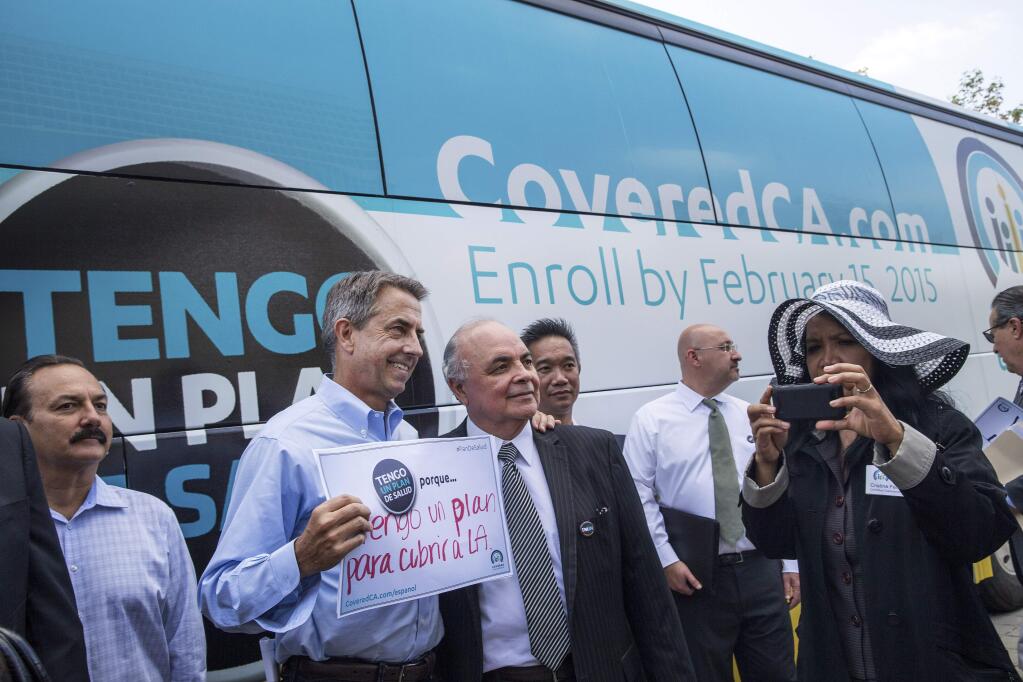 Peter Lee, second left, the executive director of Covered California, poses with enrollees in the state-run health insurance exchange in front of Los Angeles City Hall. (MONICA ALMEIDA / New York Times, 2014)
