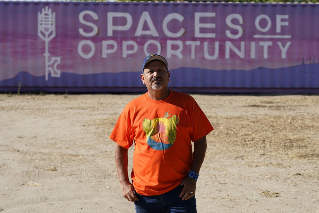 Masavi Perea, organizing director for Chispa Arizona, poses for a photograph at the entrance to the community garden at Spaces of Opportunity on May 18, 2022, in Phoenix. (AP Photo/Ross D. Franklin)