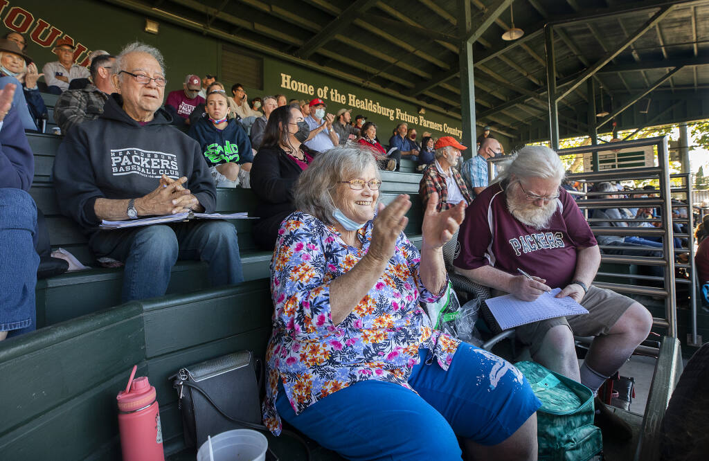 From left, die-hard fans Joe Gellura, Lisa Smith and Jack Chalmers keep score and root for their Prune Packers on the opening day of the baseball season in the 100th year of Healdsburg Recreation Park on Tuesday, June 8, 2021.  (Photo by John Burgess/The Press Democrat)