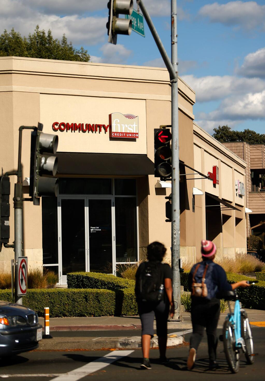 Pedestrians cross the street in front of the the Community First Credit Union branch at the corner of College and Mendocino Avenues, in Santa Rosa, California on Tuesday, October 4, 2016. (Alvin Jornada / The Press Democrat)