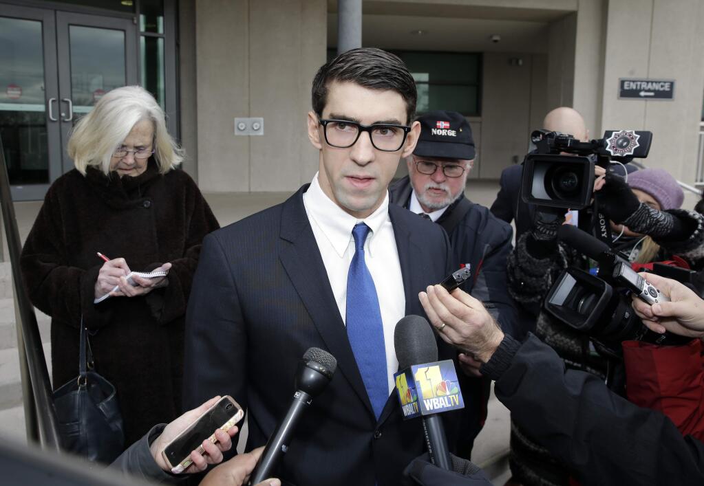 Olympic swimmer Michael Phelps speaks with reporters after he walked out of a courthouse where he pleaded guilty to drunken driving, Friday, Dec. 19, 2014, in Baltimore. He was sentenced to a year in prison for the Sept. 30 arrest, but the prison sentence is suspended. He must be on probation for a year and a half.(AP Photo/Patrick Semansky)