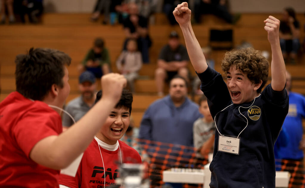 From left, Griffin Cleland, Damian Padilla and Jack Anglim of Petaluma Accelerated Charter School celebrate their first place finish in the King of the Hill contest during the Sonoma County Robotics Challenge, at Elsie Allen High School, Saturday, April 30, 2022 in Santa Rosa.  (Kent Porter / The Press Democrat) 2022