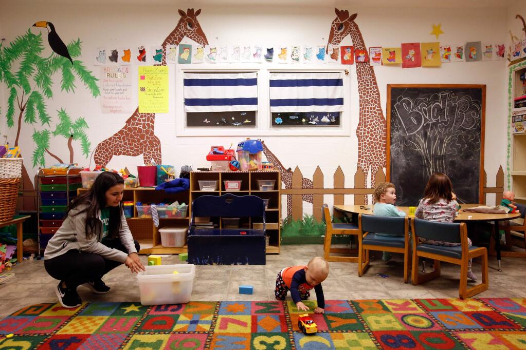 Volunteer Dahlia Viramontes, left, watches over a small group of children day care center at the Catholic Charities Family Support Center, which was formerly the hospital operating room, in the building's previous form, in Santa Rosa, California, on Thursday, February 15, 2018. (Alvin Jornada / The Press Democrat)