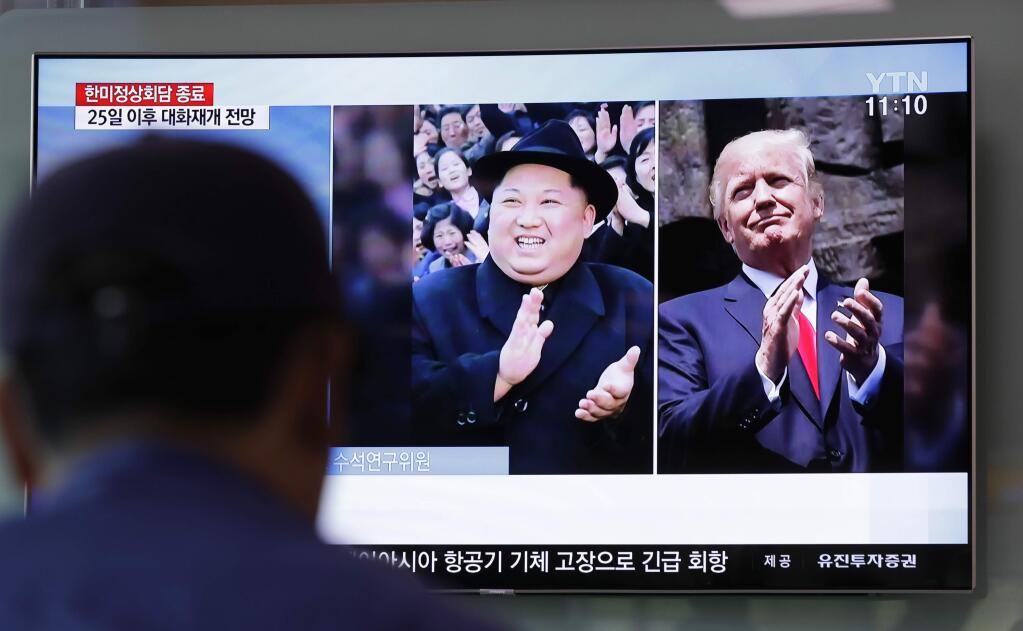 A man watches a TV screen showing file footage of U.S. President Donald Trump, right, and North Korean leader Kim Jong Un, left, during a news program at the Seoul Railway Station in Seoul, South Korea, Wednesday, May 23, 2018. North Korea on Wednesday allowed South Korean journalists to join the small group of foreign media in the country to witness the dismantling of its nuclear test site this week, Seoul officials said. (AP Photo/Lee Jin-man)