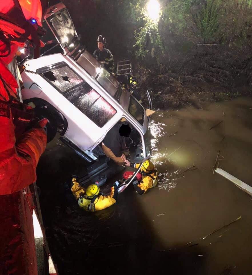 A woman and her dog were rescued Friday night after her car fell 10 feet off a bridge, partially submerging the car and leaving her in a nearly vertical position, Santa Rosa fire official said. (City of Santa Rosa Fire Department)