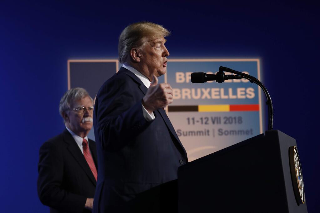 U.S. President Donald Trump speaks during a news conference before departing the NATO Summit in Brussels, Belgium, Thursday, July 12, 2018. On stage with Trump is National Security Adviser John Bolton. (AP Photo/Pablo Martinez Monsivais)