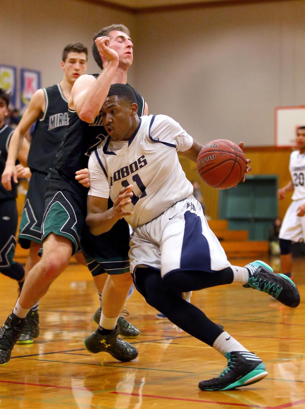 Elsie Allen's Jalen Busby is fouled by Miramonte's Jackson Wegener as he drives to the basket during their game in Santa Rosa on Tuesday, February 24, 2015. (Christopher Chung/ The Press Democrat)