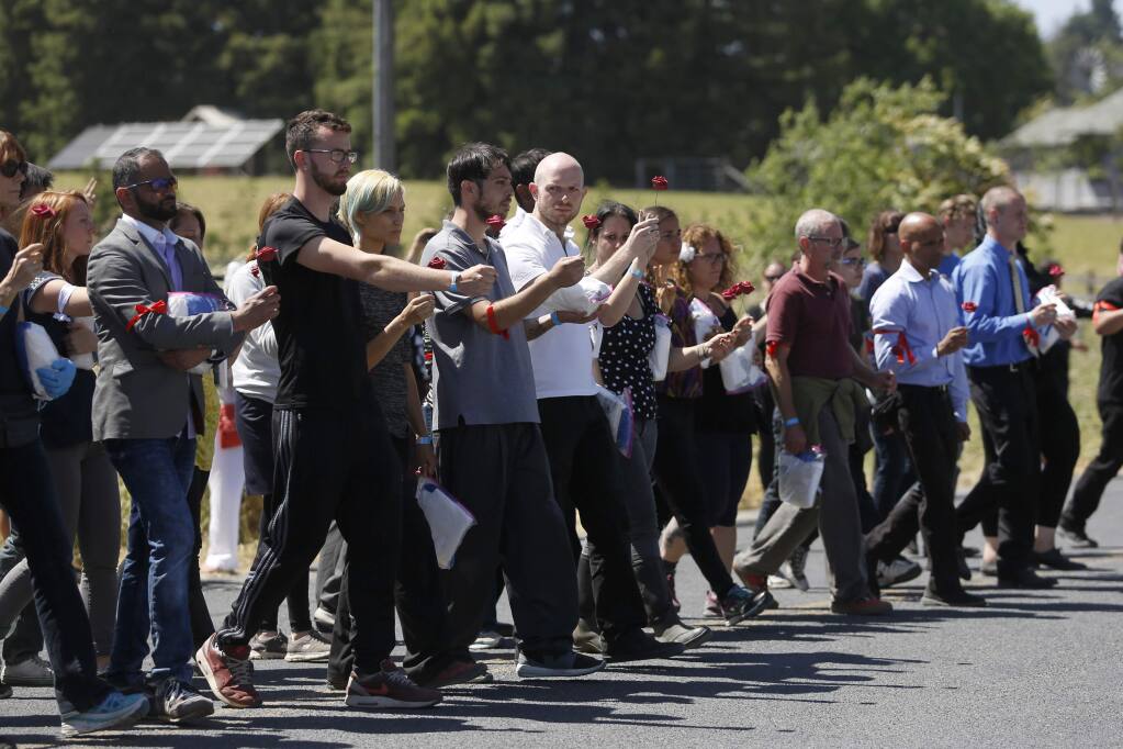 Protesters organized by Direct Action Everywhere, an animal rights network, approach a line of Sonoma County Sheriff's deputies in order to be arrested for trespassing at Weber Family Farms on Tuesday, May 29, 2018 in Petaluma, California . (BETH SCHLANKER/The Press Democrat)
