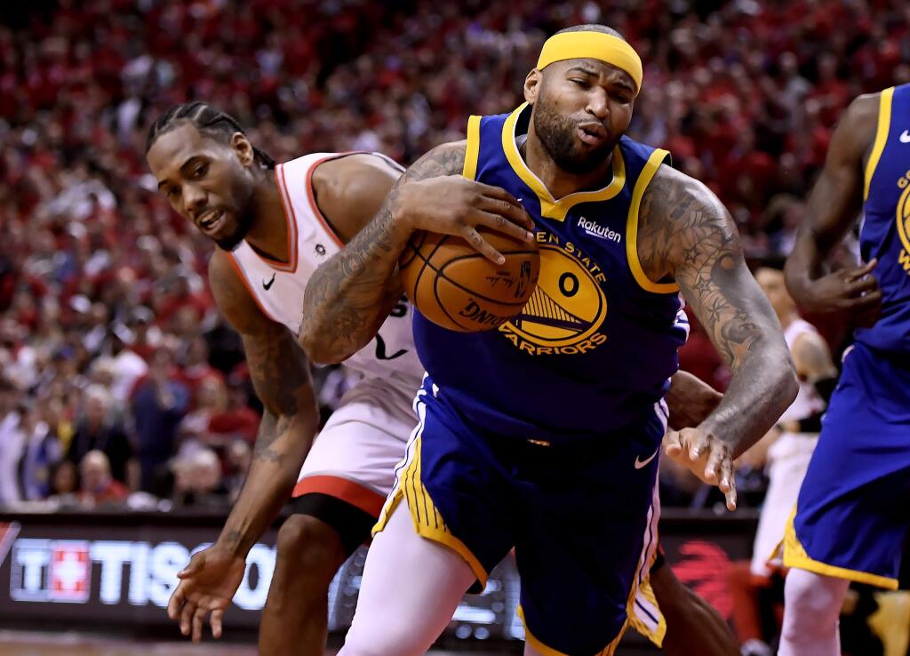 Toronto Raptors forward Kawhi Leonard (2) looks on as Golden State Warriors centre DeMarcus Cousins (0) stumbles with the ball during the second half of Game 2 of basketball's NBA Finals, Sunday, June 2, 2019, in Toronto. (Frank Gunn/The Canadian Press via AP)
