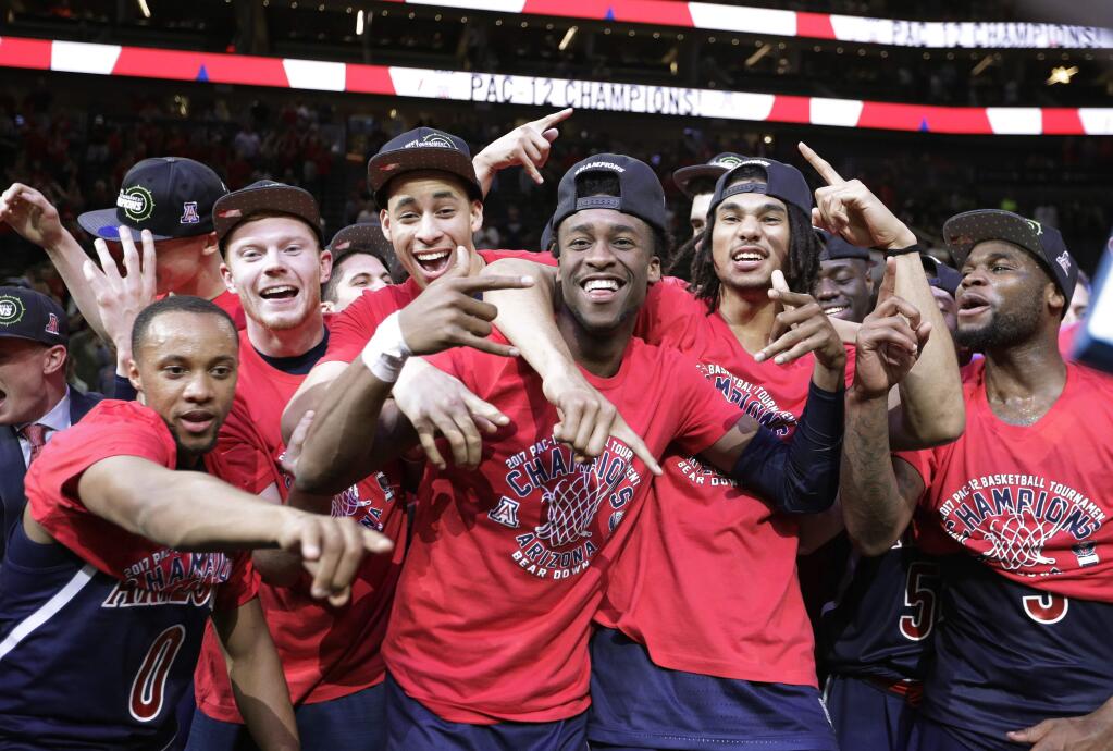 Arizona players celebrate as they pose for photographers after defeating Oregon 83-80 in an NCAA college basketball game for the championship of the Pac-12 men's tournament Saturday, March 11, 2017, in Las Vegas. (AP Photo/John Locher)