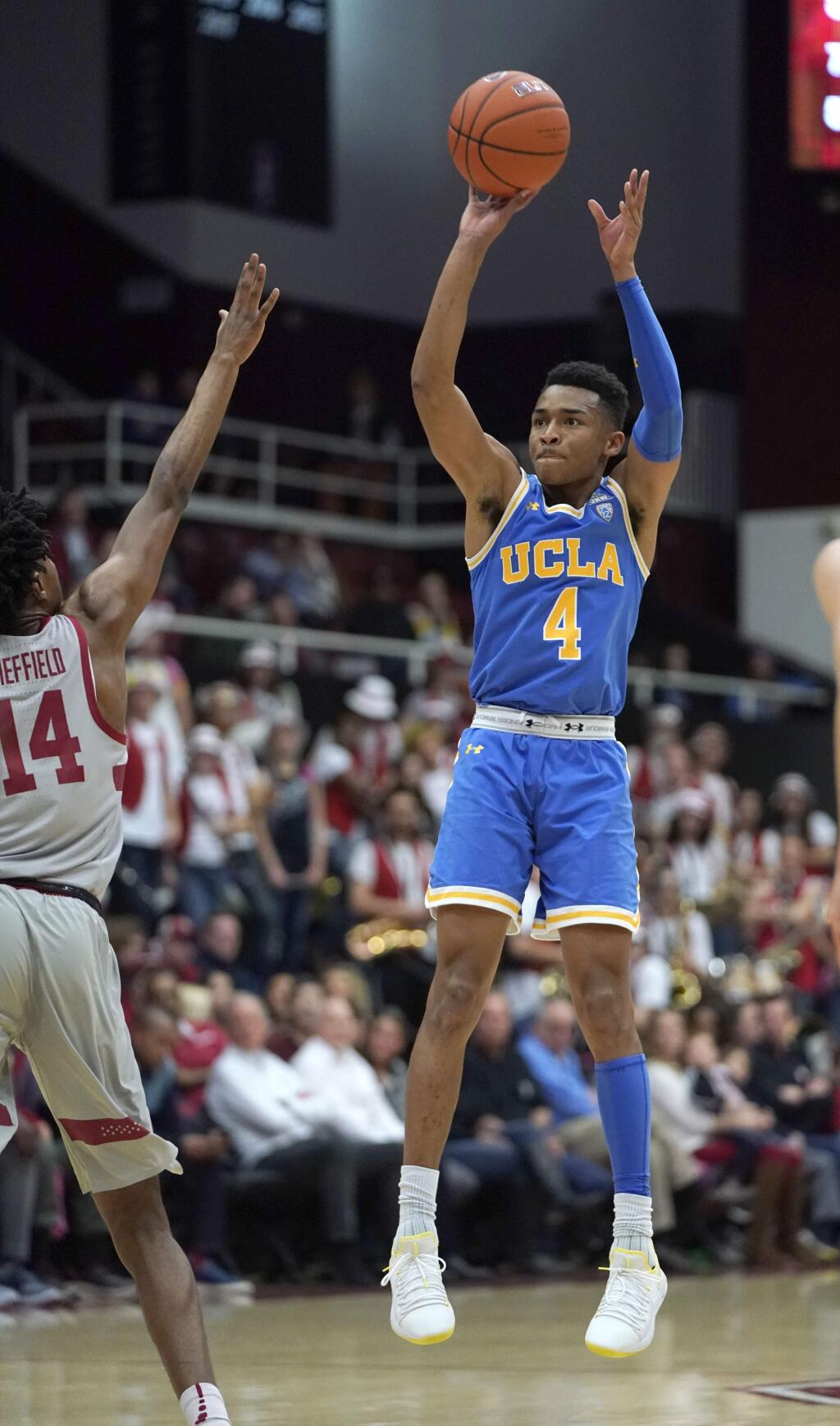 UCLA guard Jaylen Hands (4) takes a 3-point shot over Stanford guard Marcus Sheffield (14) during the first half of an NCAA college basketball game Saturday, Feb. 16, 2019, in Stanford, Calif. (AP Photo/Tony Avelar)