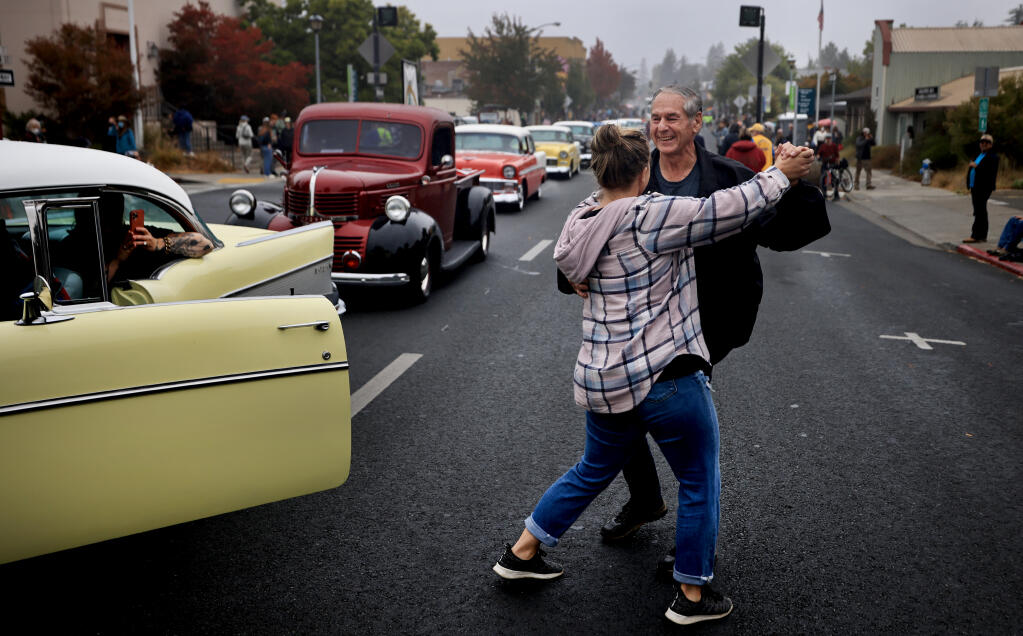 Gus St. Marie with the Redwood Empire Classics Car Club and Apple Blossom Parade spectator Karli Irons of Sebastopol, dance to ’50s music near the end of Saturday’s parade. (Kent Porter / The Press Democrat)