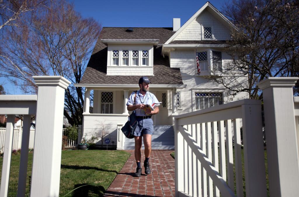 Mail carrier Tom Feige delivers mail along McDonald Avenue in Santa Rosa, on Wednesday, Feb. 6, 2013. (CHRISTOPHER CHUNG/ PD FILE)