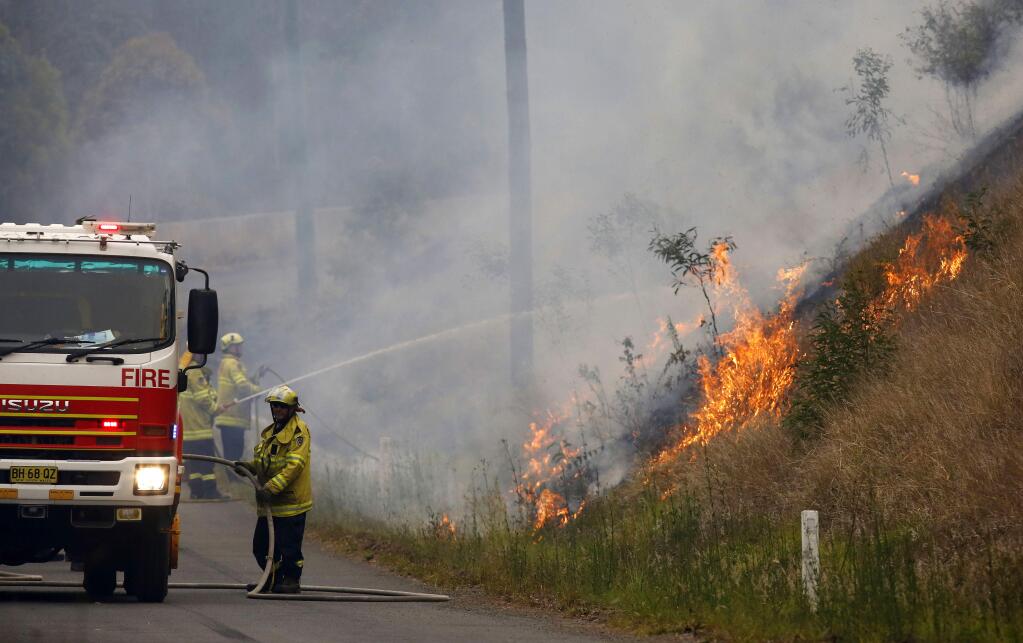 In Monday, Nov. 11, 2019, photo, firefighters work on a controlled burn in Koorainghat, New South Wales state, Australia. Hundreds of schools remained closed across Australia's most populous state on Tuesday, Nov. 12, and residents were urged to evacuate woodlands for the relative safety of city centers as authorities braced for extreme fire danger. (Darren Pateman/AAP Images via AP)
