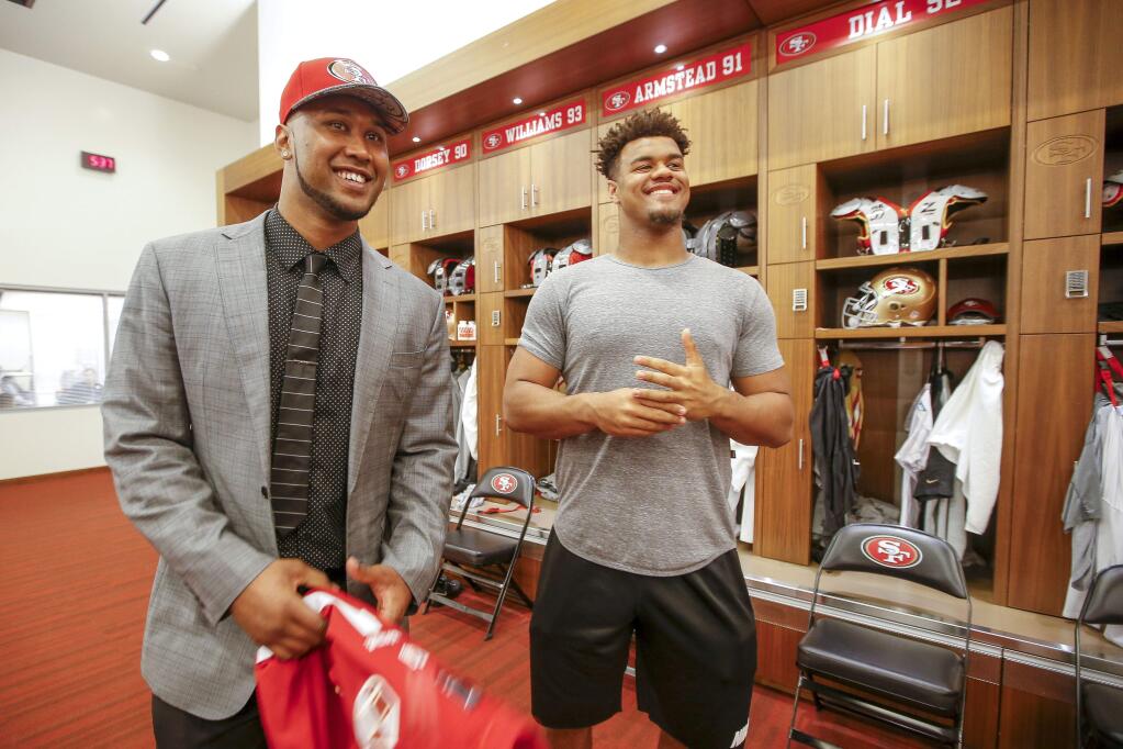 San Francisco 49ers NFL first round draft pick, DeForest Buckner, left, a defensive lineman from Oregon, meets with former Oregon teammate Arik Armstead, right, during an NFL football news conference in Santa Clara, Calif., Friday, April 29, 2016. (AP Photo/Tony Avelar)