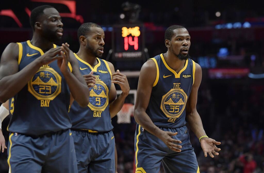 Golden State Warriors forward Kevin Durant, right, reacts as he fouls out of the game while forward Draymond Green, left, and guard Andre Iguodala look on during the overtime portion against the Los Angeles Clippers Monday, Nov. 12, 2018, in Los Angeles. The Clippers won 121-116 in overtime. (AP Photo/Mark J. Terrill)