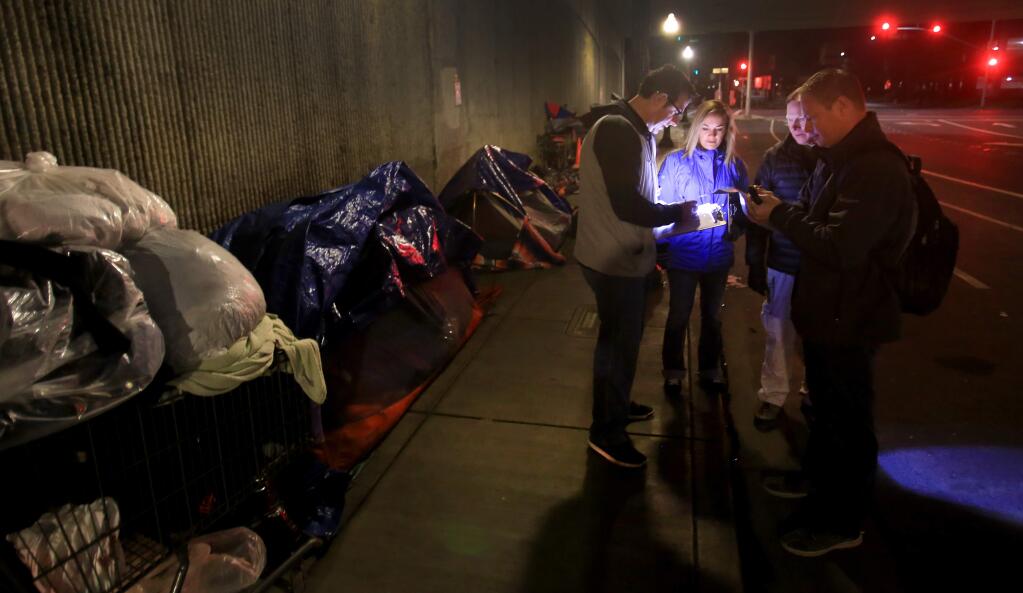 From left, Jonathan Wolf of the Santa Rosa Police Department, Tracy Weitzenberg, of the Santa Rosa Chamber of Commerce, Tom Schwedhelm, of the Santa Rosa City Council and Jason Brandt of SRPD take a tally of homeless at the Sixth Street underpass in Santa Rosa, Friday Jan. 27, 2017 as part of the annual homeless count. (Kent Porter / Press Democrat) 2017