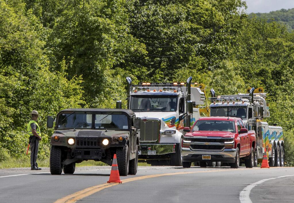 Military police direct traffic along Route 293 near the site where an armored personnel vehicle overturned killing at least one person, Thursday, June 6, 2019, in Cornwall, N.Y. West Point officials say one cadet was killed and over a dozen people were injured when a vehicle they were riding in for summer training overturned. The accident occurred near Camp Natural Bridge, an area where cadet summer training takes place. (AP Photo/Allyse Pulliam)