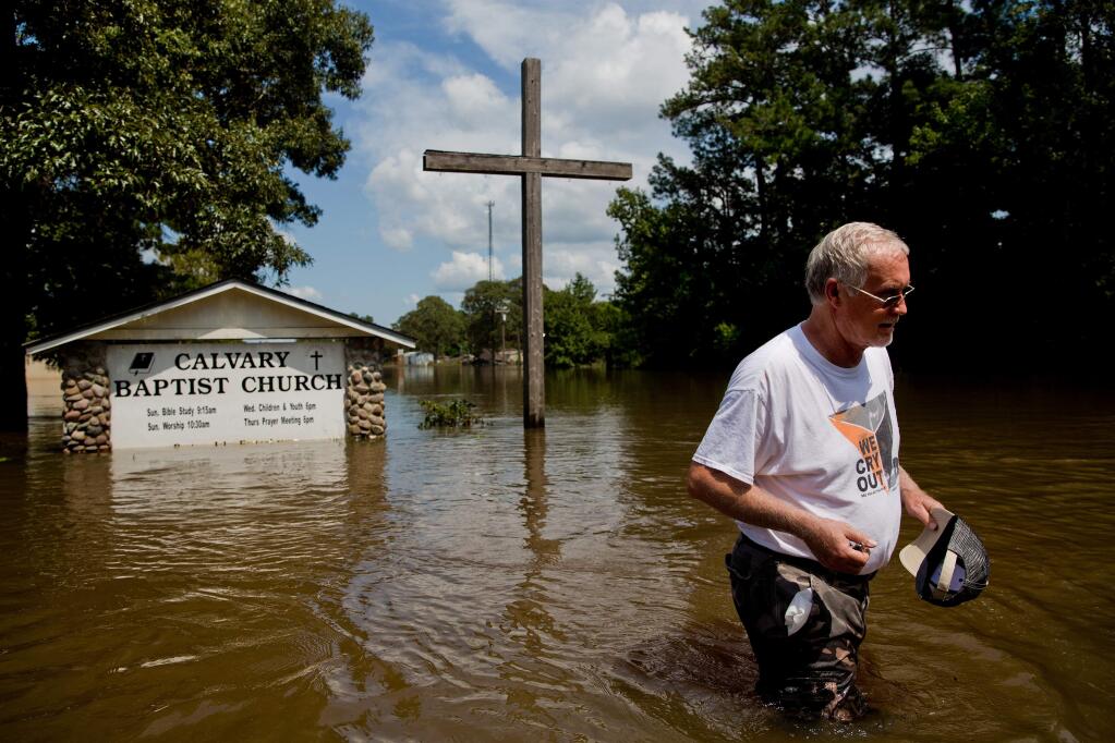 Pastor John Fortenberry surveys flood damage outside the Calvary Baptist Church in Deweyville, Texas following Hurricane Harvey. (SCOTT McINTYRE / New York Times)