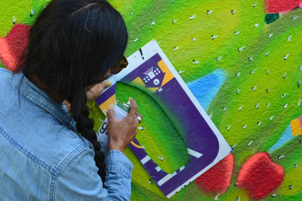 Raizes Collective Founder and Executive Director Isabel Lopez spray paints cacti with a stencil on the new mural at Sonoma Valley High. (Photo Vince Basada)