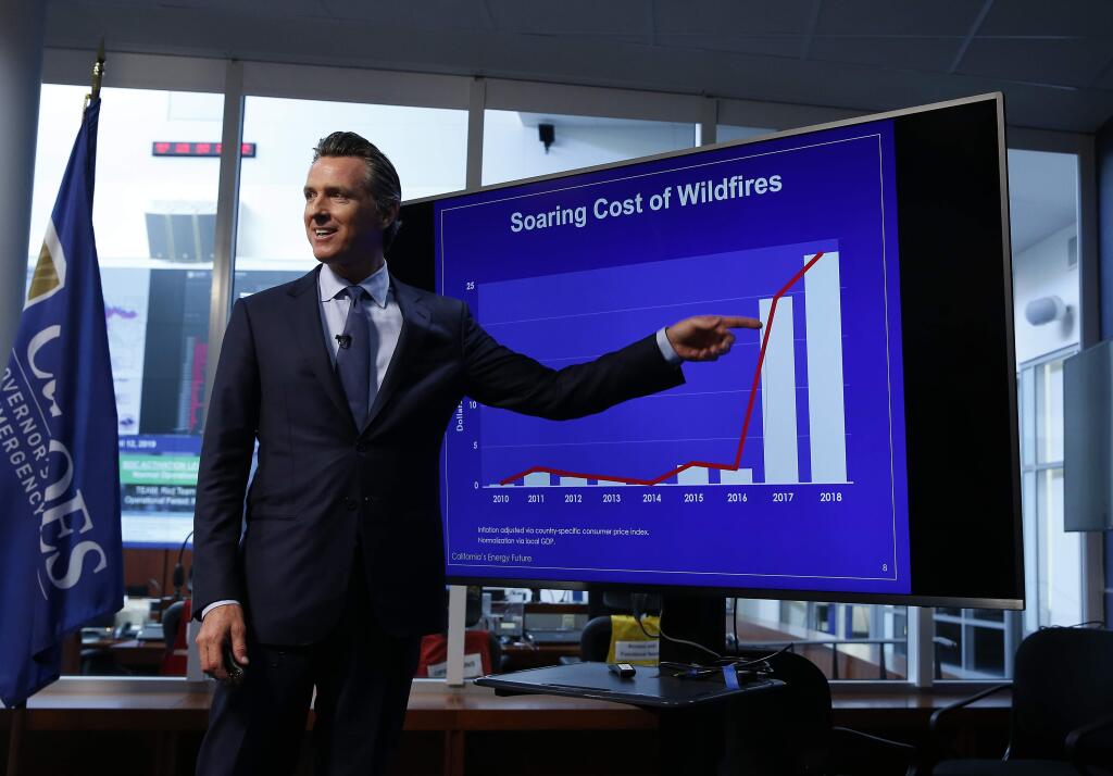 Gov. Gavin Newsom points to graph showing the increase in the risk to wildfires due to climate change. Newsom released a task force report on utilities and wildfires on Friday. (RICH PEDRONCELLI / Associated Press)