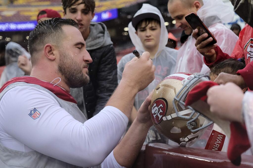 San Francisco 49ers offensive tackle Joe Staley signs a helmet prior to a game against the Washington Redskins, Sunday, Oct. 20, 2019, in Landover, Md. (AP Photo/Mark Tenally)