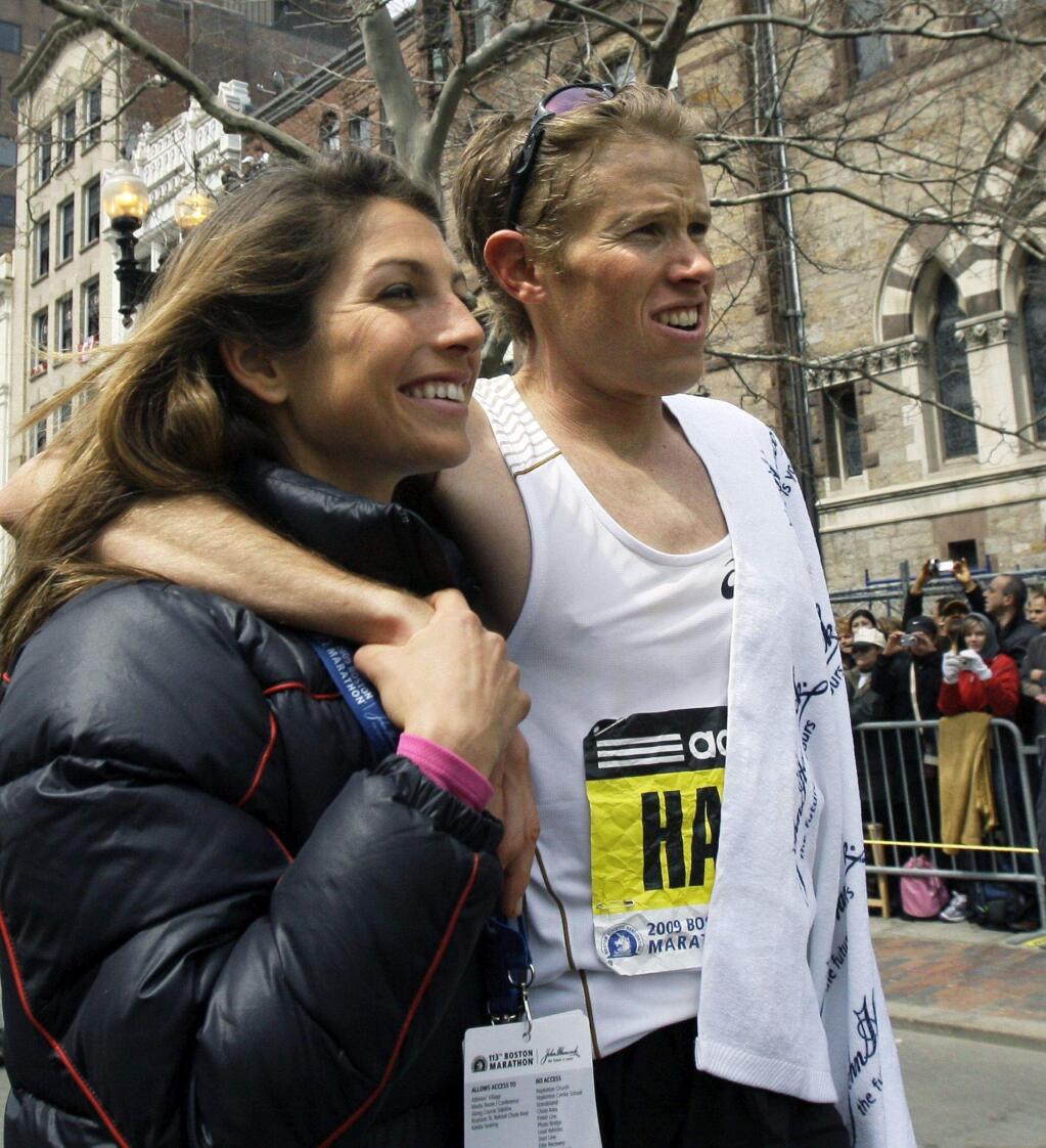 Third-place mens finisher Ryan Hall leans on his wife, Sara, at the finish line in Boston during the 113th running of the Boston Marathon Monday, April 20, 2009. (AP Photo/Elise Amendola)